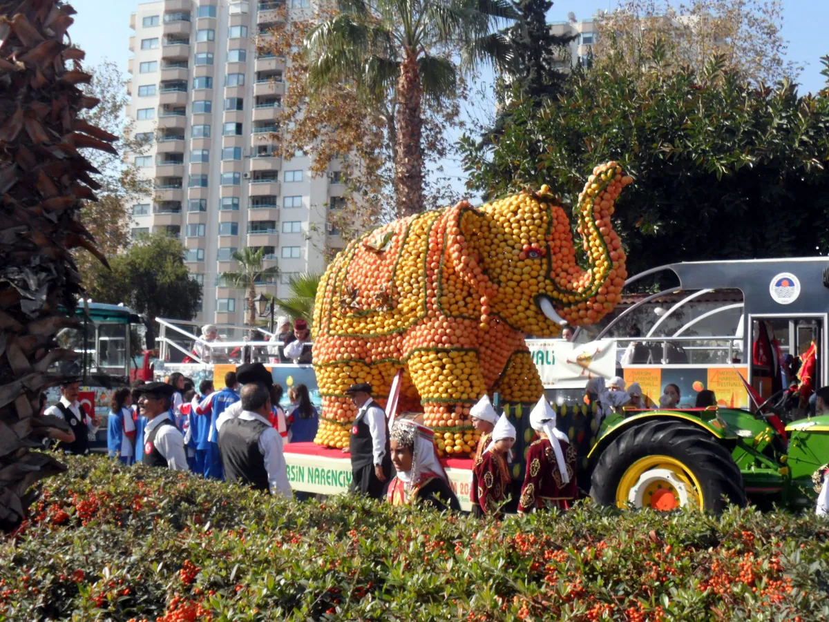 A citrus-fruit sculpture of an elephant at the Mersin Citrus Festival, with performers in traditional dress